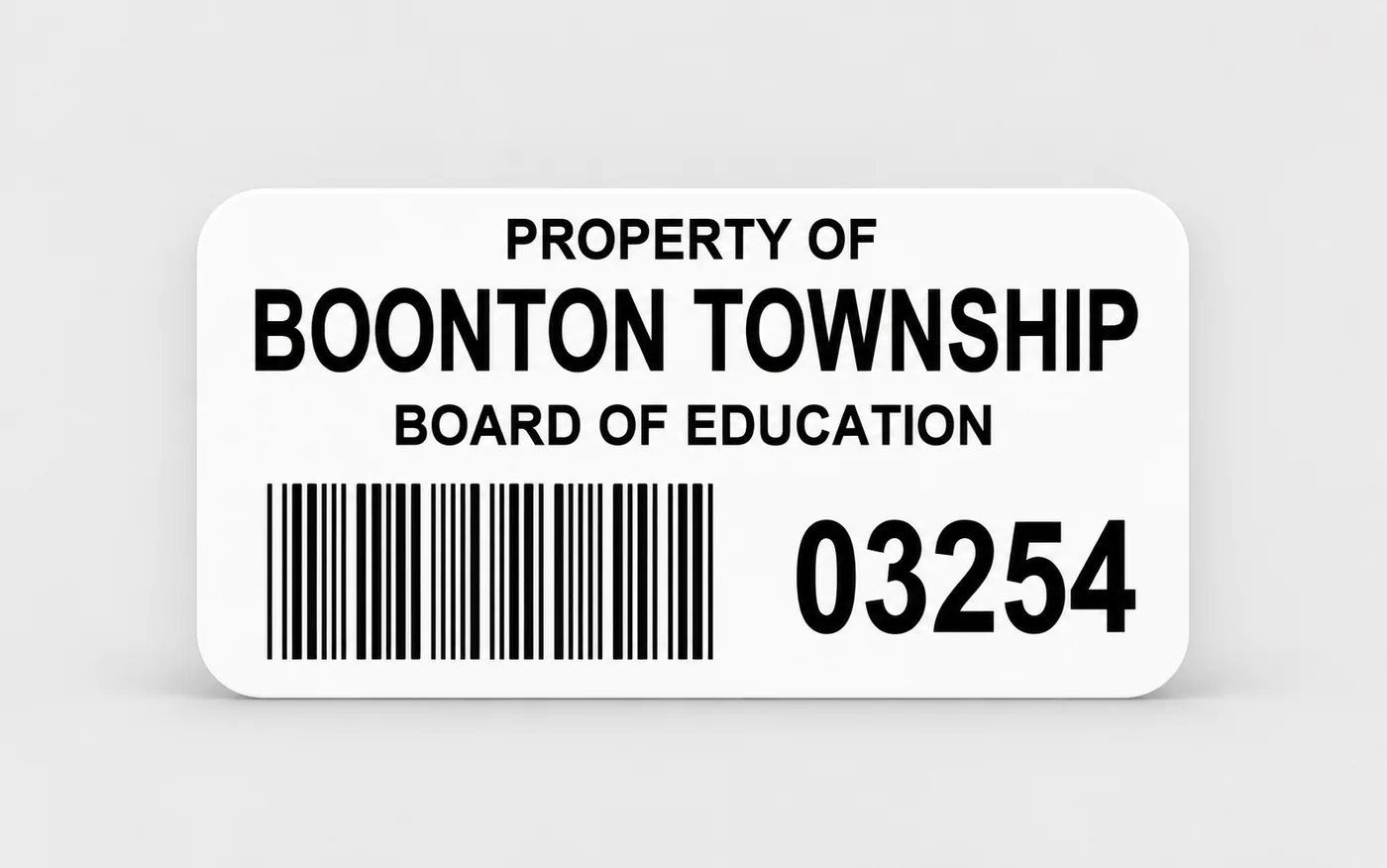 White asset tag reading Property of Boonton Township Board of Education, with a barcode and the number 03254